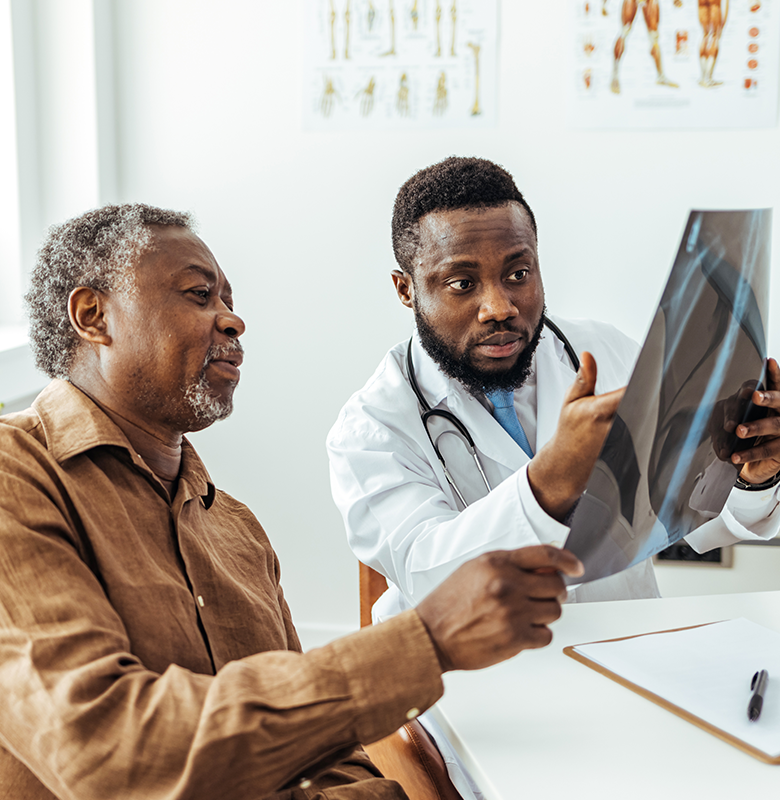 A patient looks at a lung x-ray with a physician.