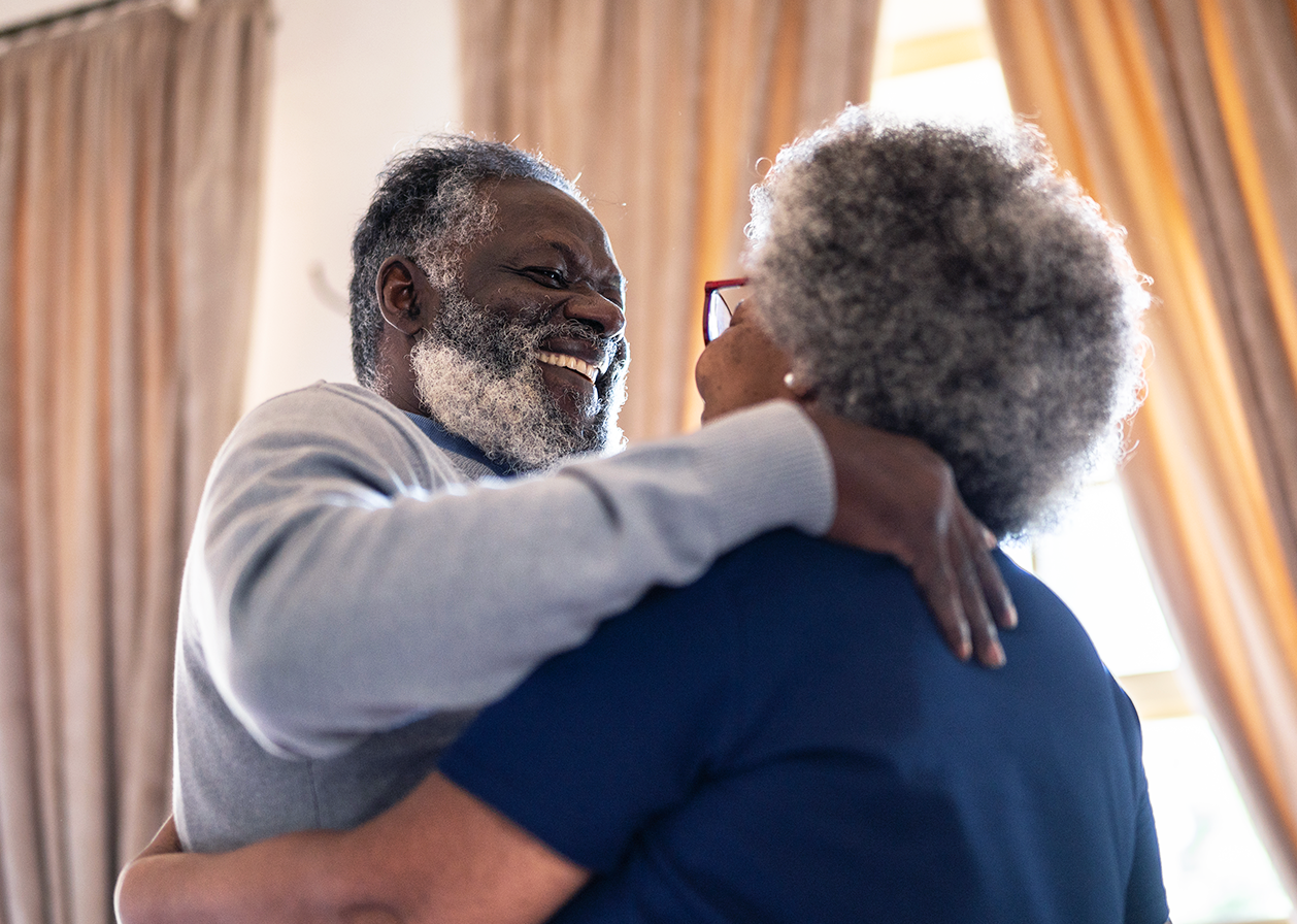 An older Black couple dancing.