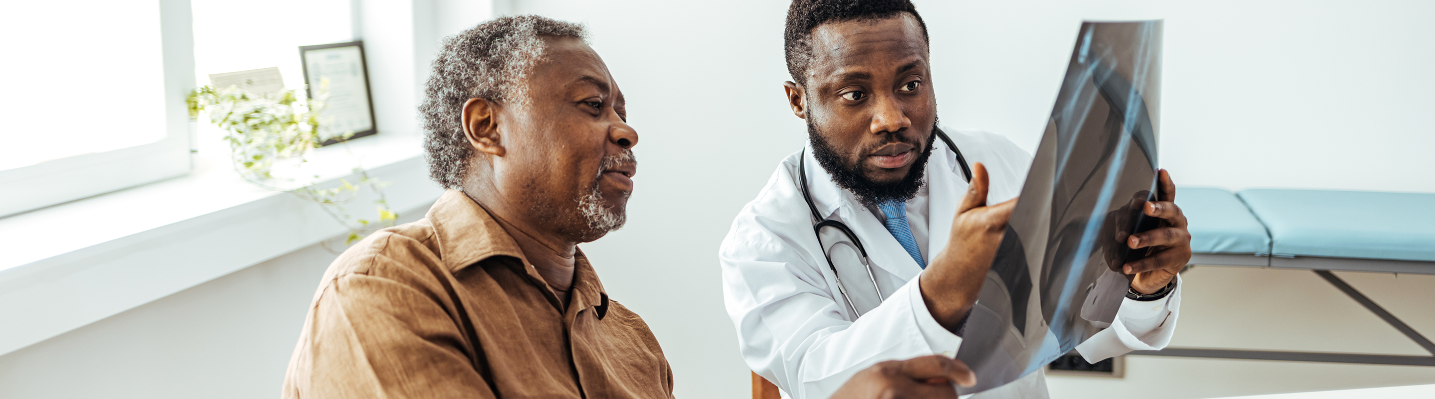 A patient looks at a lung x-ray with a physician.