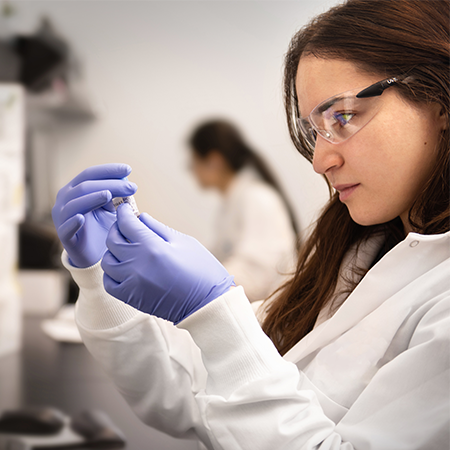 A lab worker examines a label on a vial.